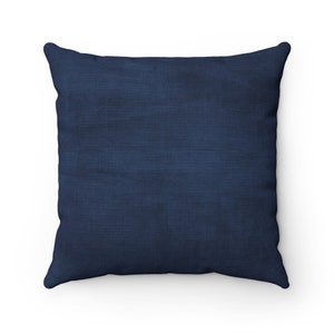 May include: A solid navy blue throw pillow with a soft, textured fabric.