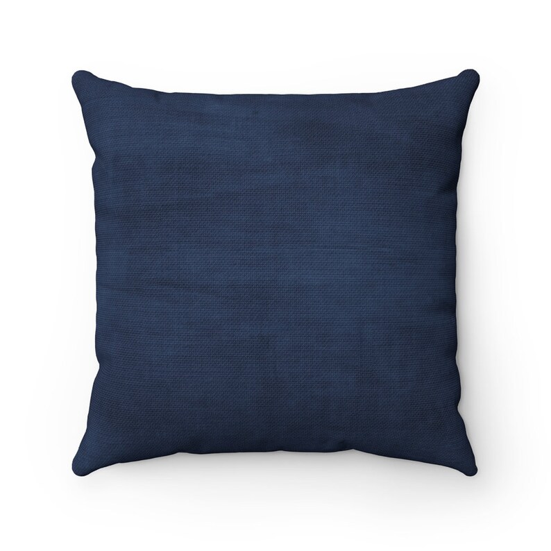 May include: A solid navy blue throw pillow with a soft, textured fabric.