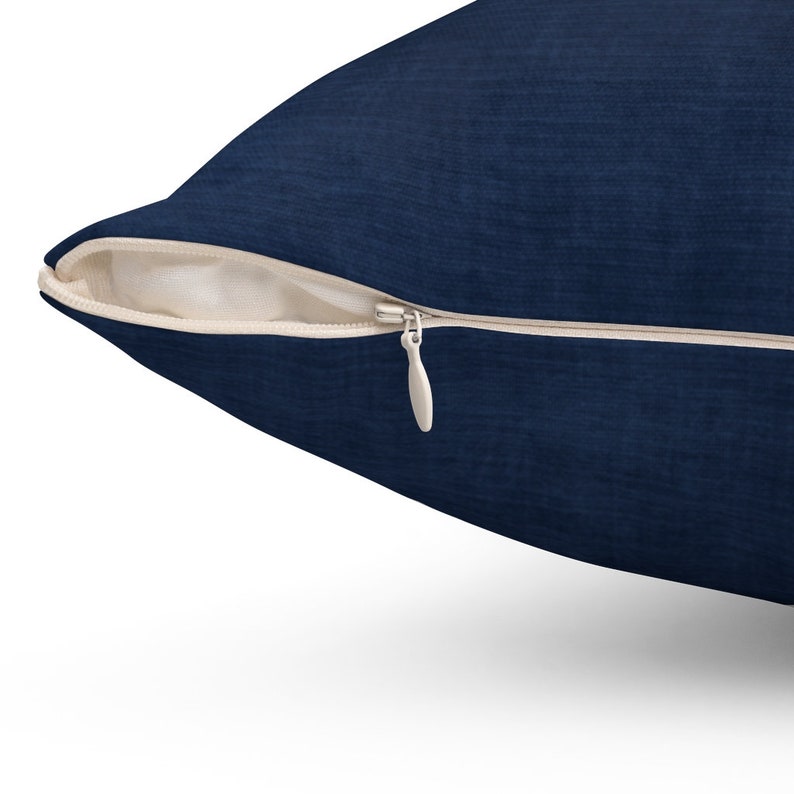 May include: A navy blue pillow cover with a zipper closure. The zipper is open and the fabric is soft and textured.