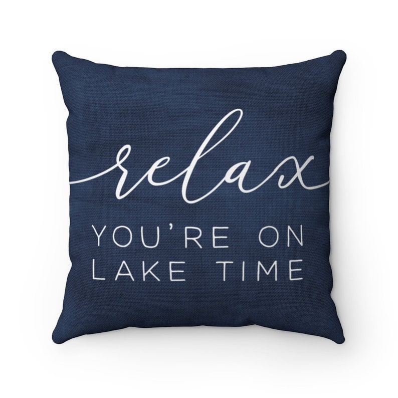 May include: Navy blue throw pillow with white text that reads "relax you're on lake time".