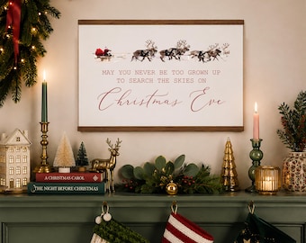 May include: A rectangular wall hanging featuring a white background with a wooden frame at the top and bottom. The print displays a graphic of Santa in a sleigh pulled by reindeer, with the text: MAY YOU NEVER BE TOO GROWN UP TO SEARCH THE SKIES ON Christmas Eve.