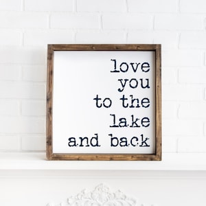 May include: A wooden framed sign with the text "love you to the lake and back" in navy blue lettering.