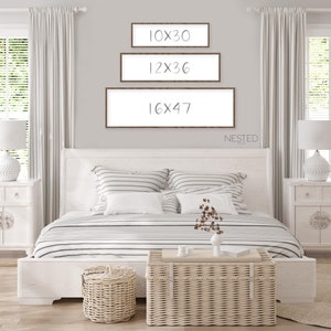 Puede incluir: Tres piezas rectangulares de arte mural con marcos marrones y fondos blancos se exhiben sobre una cama. Los tama&ntilde;os son 25x76 cm, 30x91 cm y 41x120 cm. La palabra "NESTED" est&aacute; debajo del marco m&aacute;s grande. El dormitorio tiene una combinaci&oacute;n de colores neutros.