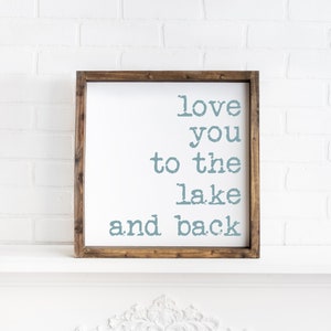 May include: A wooden framed sign with the text "love you to the lake and back" in blue lettering.