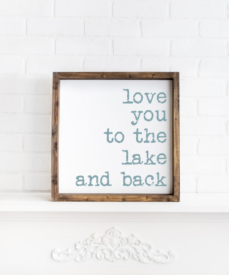May include: A wooden framed sign with the text "love you to the lake and back" in blue lettering.