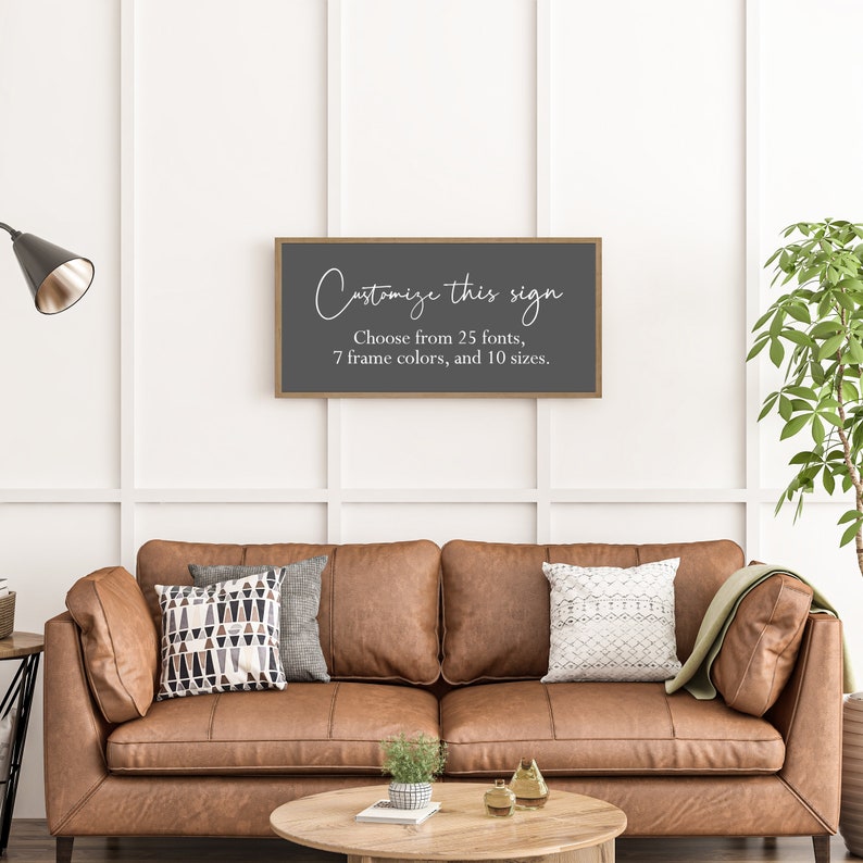 Pu&ograve; includere: Un'insegna da parete rettangolare con sfondo grigio scuro e cornice in legno chiaro. L'insegna presenta un testo bianco che recita: Customize this sign. Choose from 25 fonts, 7 frame colors, and 10 sizes. L'insegna &egrave; montata su una parete bianca.