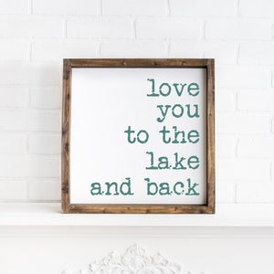 May include: A wooden framed sign with the text "love you to the lake and back" in teal green lettering.