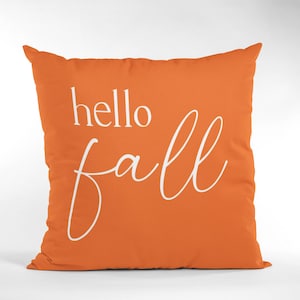 K&ouml;nnte beinhalten: Orangefarbener Dekokissen mit wei&szlig;em Text "hello fall".