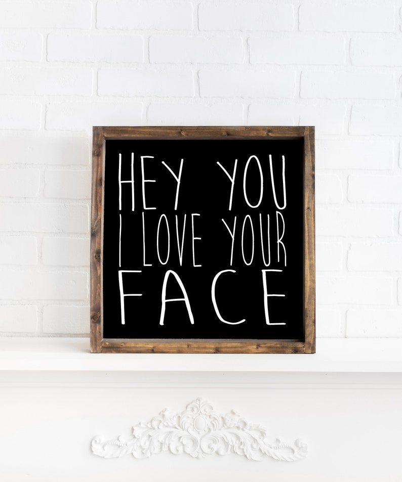 K&ouml;nnte beinhalten: Schwarzes, gerahmtes Schild mit wei&szlig;em Text, der "Hey you I love your face" lautet.