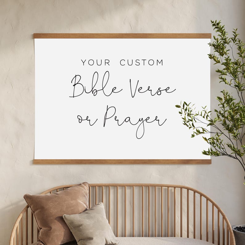 May include: A rectangular white wall hanging featuring the black text YOUR CUSTOM Bible Verse or Prayer. The print is secured between two horizontal wooden bars at the top and bottom, creating a clean display for personalised wall art.