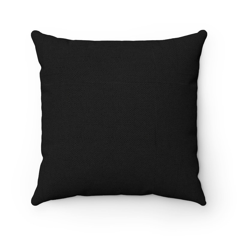 May include: A black square pillow with a textured fabric surface.