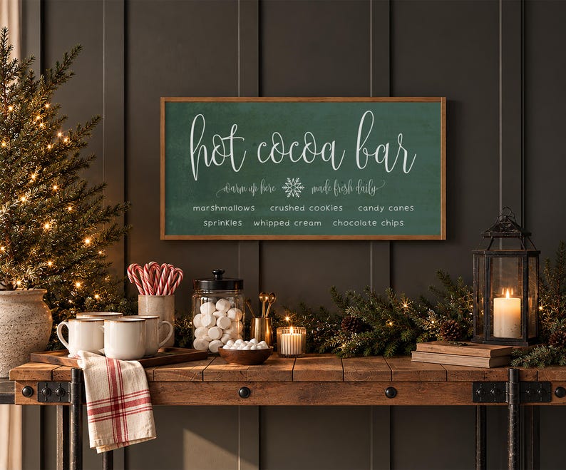 May include: A rectangular wooden sign with a dark green background and a light wood frame. The text reads "hot cocoa bar" in large script, with "warm up here" and "made fresh daily" flanking a snowflake, and a list of toppings below.