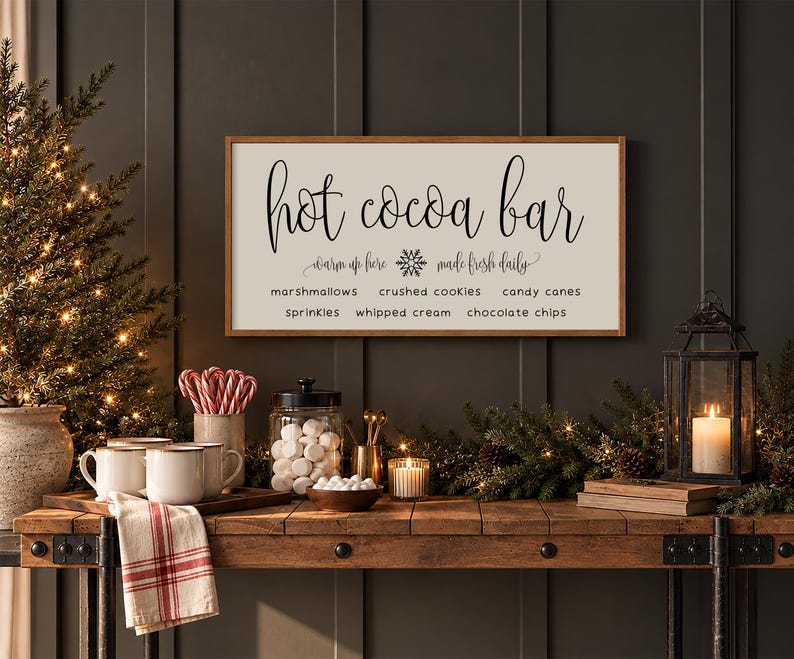 May include: A rectangular wooden sign with a white background and a brown frame featuring the black text Hot cocoa bar, warm up here, made fresh daily, and a list of toppings including marshmallows, crushed cookies, candy canes, sprinkles, whipped cream, and chocolate chips.