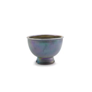 May include: A small, iridescent ceramic bowl with a flared lip and a short, wide foot. The bowl has a blue, green, and purple iridescent glaze.