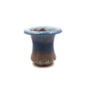 May include: A small ceramic planter with a flared rim, featuring a reactive glaze that transitions from a deep blue at the top to a warm, earthy brown at the base. The surface shows a glossy finish with visible drips and color blending.