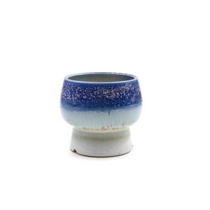 May include: A blue and white ceramic planter with a speckled glaze. The planter has a wide, round base and a slightly flared top.