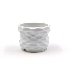 Pode incluir: Vaso de cerâmica branco com um design texturizado e geométrico. O vaso tem uma base arredondada e uma parte superior larga e aberta.