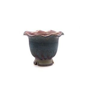 May include: A blue and brown ceramic bonsai pot with a scalloped rim and a flared base.