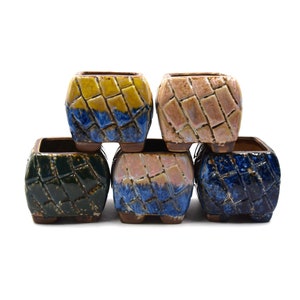 May include: Set of five small square ceramic planters with a geometric pattern. The planters are in shades of blue, green, yellow, and pink.