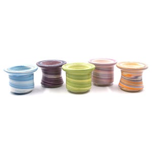 May include: A collection of five small, ceramic containers with a unique, swirled design. Each container features a different color scheme, including blue, purple, green, pink, and orange. The containers have a flared top and a cylindrical body.