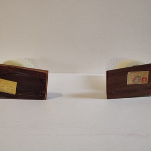 May include: Two wooden table lamps with white shades and labels on the bottom. The labels are in Japanese.