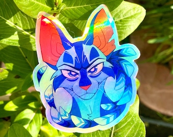 May include: A holographic sticker of a blue and red cat with a serious expression. The cat is surrounded by blue and white feathers.