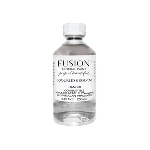 May include: A clear glass bottle of Fusion Mineral Paint Odorless Solvent. The bottle is labeled with the brand name, product name, and safety information. The bottle contains 8.45 fluid ounces (250 milliliters).