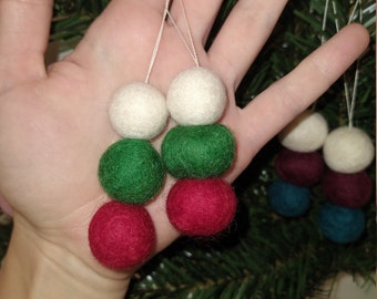 May include: A set of felt Christmas ornaments in red, green, and white. The ornaments are strung together and are ready to be hung on a Christmas tree.