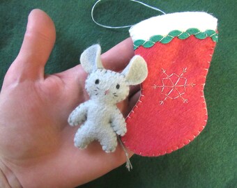 May include: A gray felt mouse ornament with a red felt stocking with a green trim and a white snowflake design.