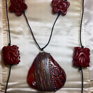 Red polymer clay abstract floral beaded pendant necklace.
