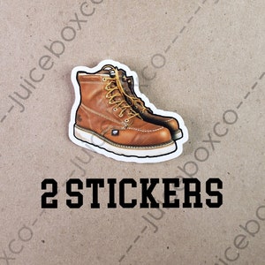 May include: Two brown leather work boots with white soles and laces. The boots are on a brown background with the text "2 STICKERS" printed below them.