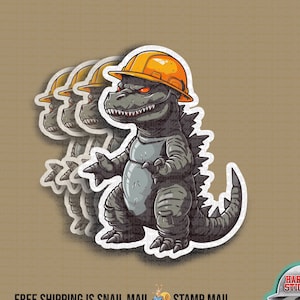May include: A sticker featuring a cartoon Godzilla wearing a yellow hard hat. The sticker is part of a set of three stickers, all featuring Godzilla in different poses. The stickers are printed on white vinyl and have a glossy finish.