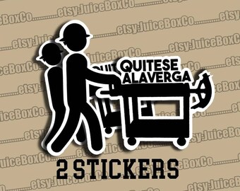 May include: Two black and white stickers featuring a cartoon illustration of two construction workers pushing a black and white cart with the text "QUITESE ALAVERGA" on the side. The text "2 STICKERS" is printed below the image.
