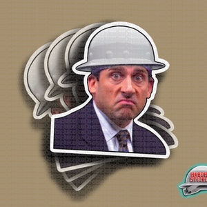 May include: A white hard hat sticker featuring a photo of a man with a serious expression wearing a white hard hat. The sticker is designed to look like a stack of stickers.