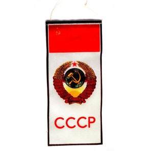 May include: A white fabric patch with a red star and hammer and sickle emblem, surrounded by a wreath of wheat. The patch has a red banner with the text "CCCP" in white letters.