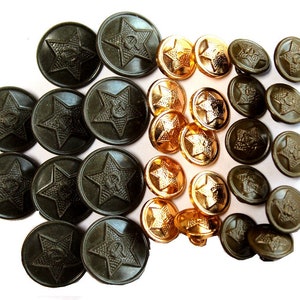 Puede incluir: Una colección de 25 botones de estilo militar. Los botones están hechos de metal y tienen un diseño de estrella con un martillo y una hoz en el centro. Los botones son de dos colores: dorado y verde oscuro.