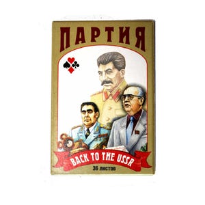 May include: A deck of playing cards with a gold border and the word "ПАРТИЯ" at the top. The card features illustrations of three men and the text "BACK TO THE USSR" in red. The deck contains 36 cards.