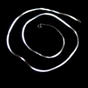 May include: A silver snake chain necklace with a clasp.