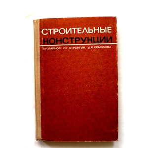 May include: A vintage book with a red cover and the title "СТРОИТЕЛЬНЫЕ КОНСТРУКЦИИ" in white lettering. The book's spine is a light tan color. The book appears to be a technical manual or textbook.