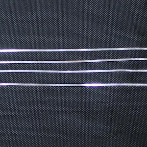 May include: Four silver chains of different lengths, 16 inches, 18 inches, 20 inches, and 24 inches, laid out on a black surface.