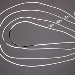 May include: Five silver snake chains of different lengths, 16 inches, 18 inches, 20 inches, 22 inches, and 24 inches.