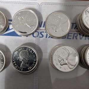 May include: A collection of silver Canadian coins featuring a variety of designs, including a portrait of Queen Elizabeth II, a caribou, and a loon.