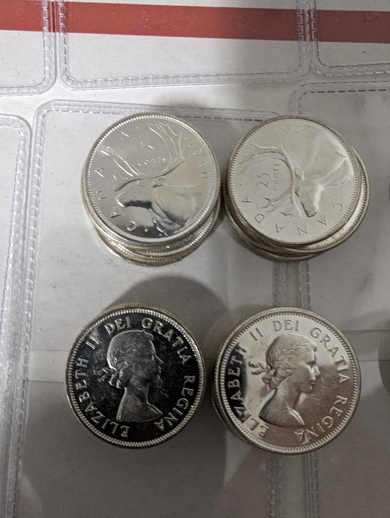 May include: A collection of silver Canadian coins featuring the profile of Queen Elizabeth II and a moose on the other side. The coins are in good condition and have a shiny finish.