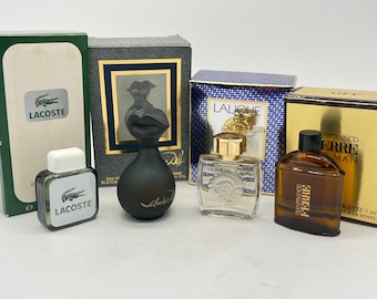 May include: A collection of six miniature perfume bottles. The bottles are in various colors and shapes, including clear glass, black glass, and brown glass. The bottles are labeled with the names of the perfumes, including "Lalique", "Lacoste", and "Franco Ferre".