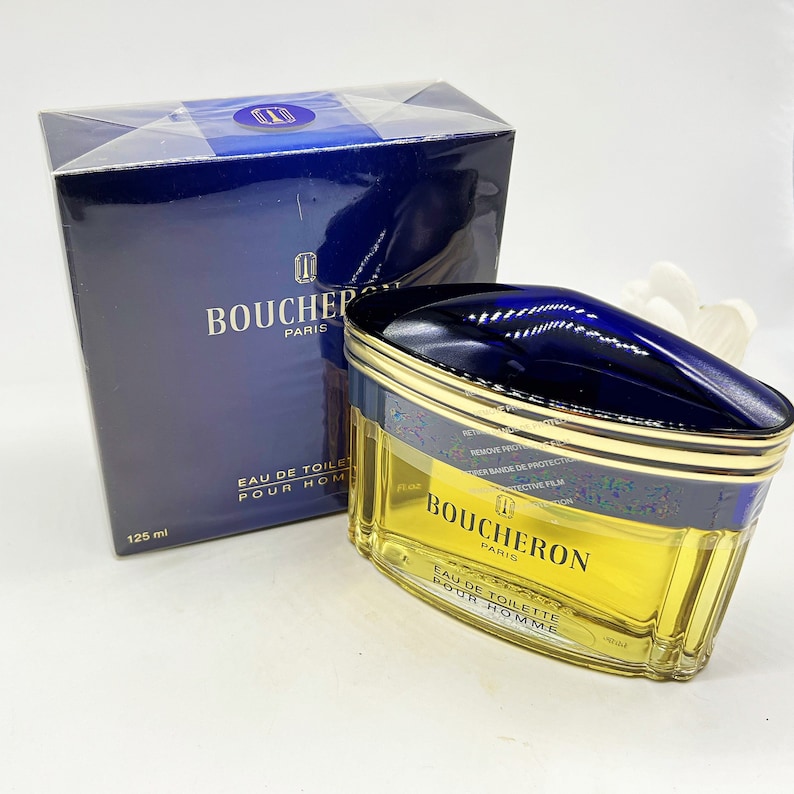 May include: A blue and gold bottle of Boucheron Paris Eau de Toilette Pour Homme cologne. The bottle is 125 ml.
