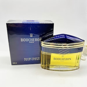 May include: A blue and gold bottle of Boucheron Paris Eau de Toilette Pour Homme. The bottle is 125 ml and has a gold cap.