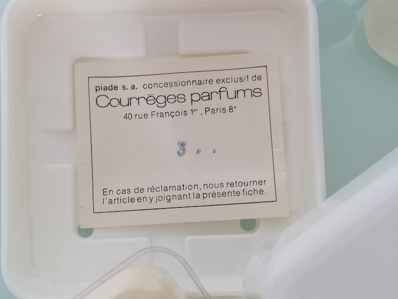 Puede incluir: Una tarjeta blanca con texto negro que dice "piade s.a. concessionnaire exclusif de Courr&egrave;ges parfums 40 rue Fran&ccedil;ois 1", Paris 8" y "En cas de r&eacute;clamation, nous retourner l'article en y joignant la pr&eacute;sente fiche."