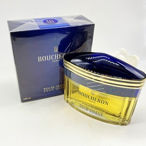 May include: A blue and gold bottle of Boucheron Paris Eau de Toilette Pour Homme cologne. The bottle is 125 ml.