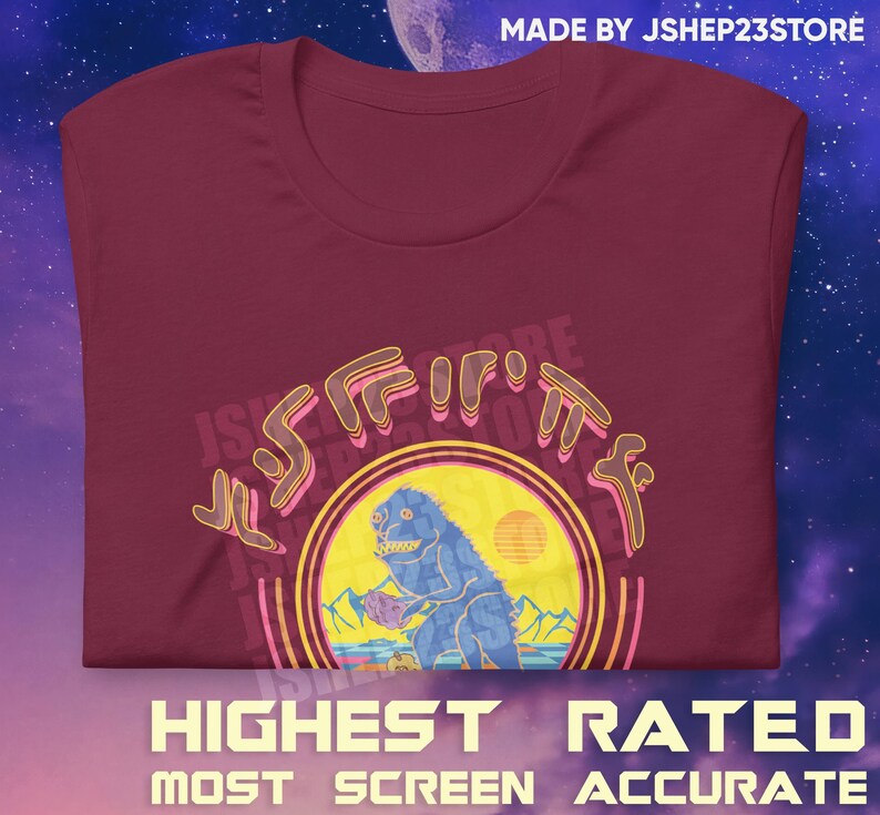 May include: A maroon t-shirt with a retro-style graphic of a blue monster holding a purple rock. The graphic is surrounded by a yellow circle with a sunset in the background. The text "JShep23Store" is written in a stylized font around the graphic.