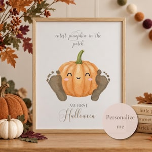 May include: A framed print featuring a cartoon orange pumpkin with a smiling face, flanked by two baby footprints. The text reads "cutest pumpkin in the patch" and "MY FIRST Halloween". A circular sticker on the frame says "Personalize me".